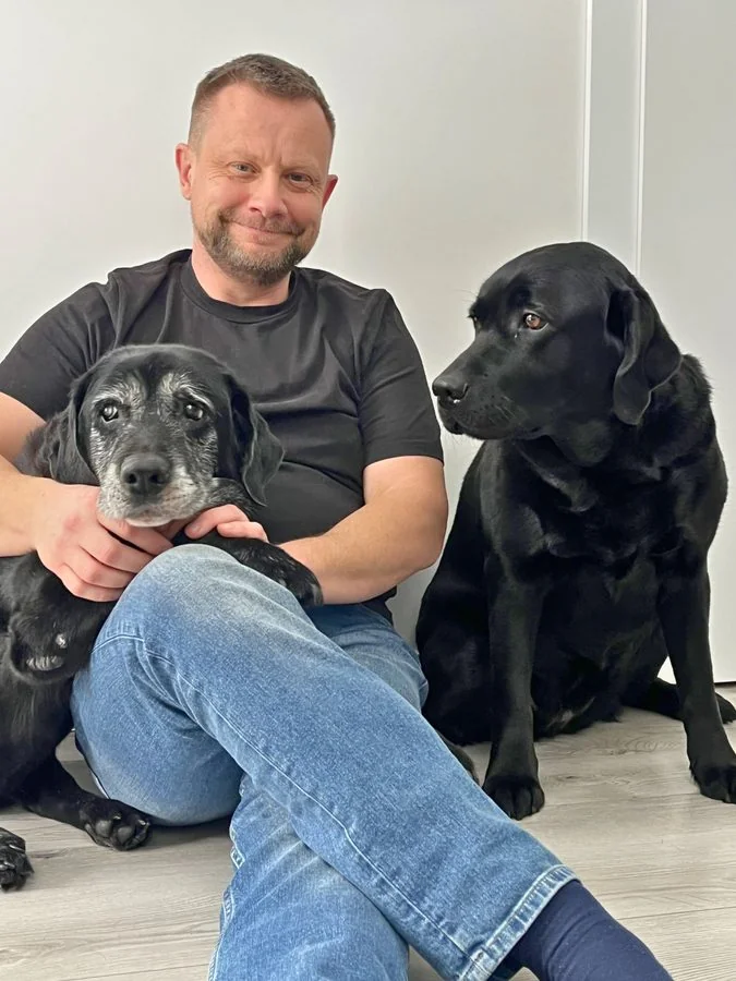 Sławomir Pięta z dwoma czarnymi labradorami